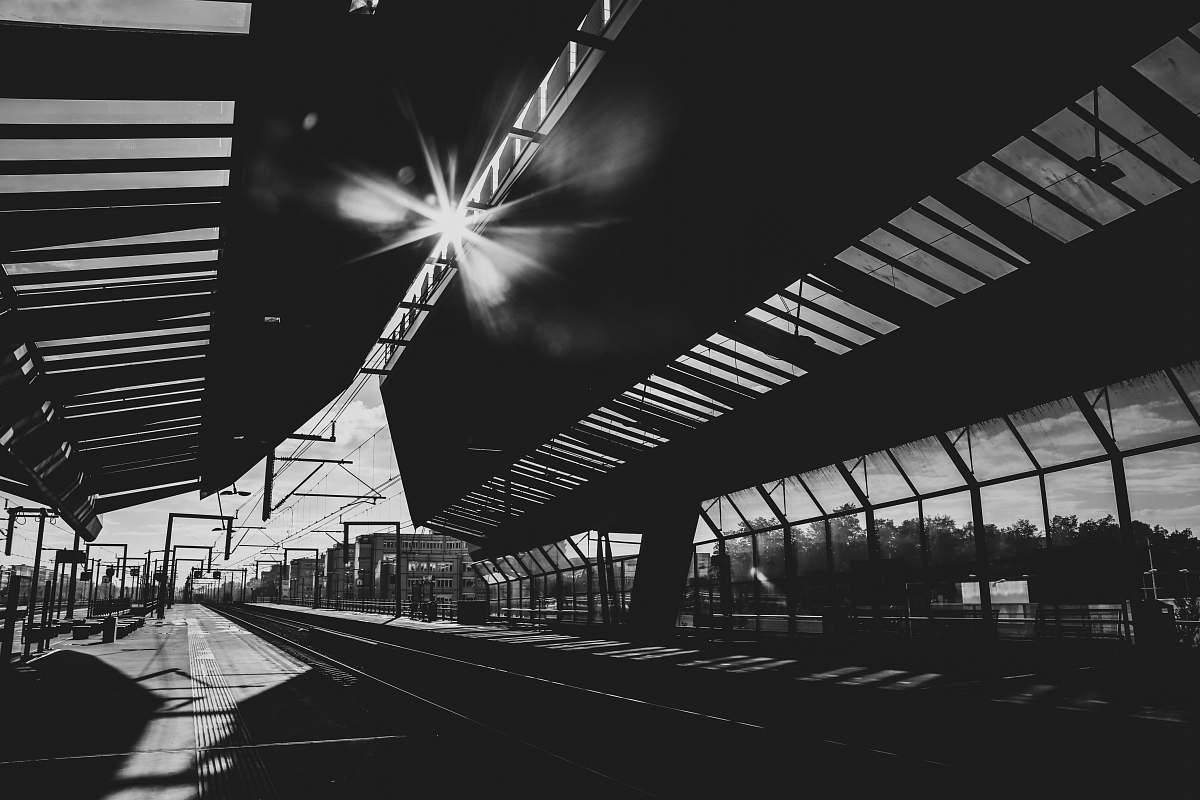 train station grayscale photography of buildng rail